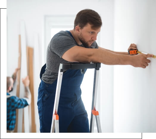 homme sur une échelle prenant des mesures